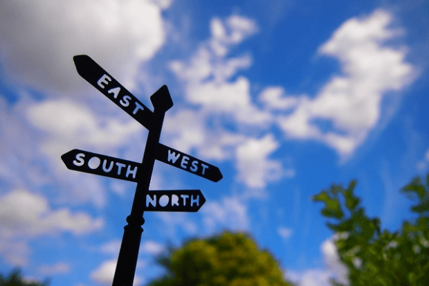 青空をバックにした方向指示標識