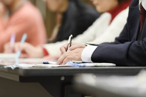 セミナーでメモをとる女性