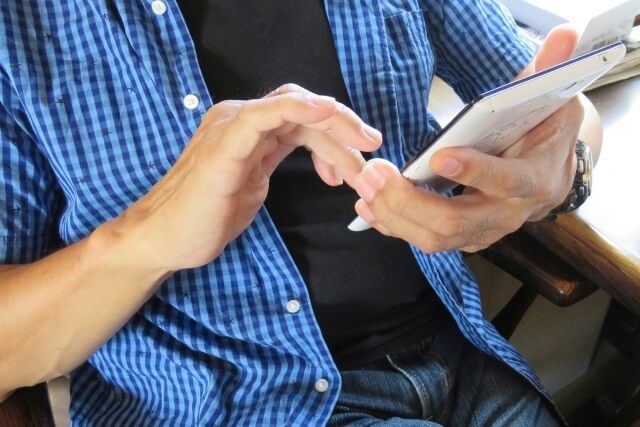 スマホで動画を見る男性