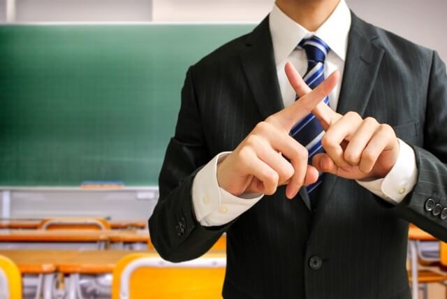 バツをする男子